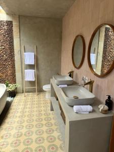 a bathroom with two sinks and a mirror at First Light Villa at Lipah Beach, Amed in Amed +22 photos