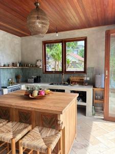 a kitchen with a large wooden island in a kitchen at First Light Villa at Lipah Beach, Amed in Amed