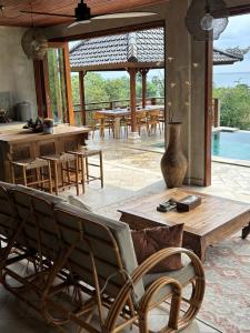 a patio with tables and chairs and a pool at First Light Villa at Lipah Beach, Amed in Amed