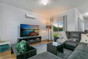 a living room with a couch and a tv at CandE on Samphire in Kingscote