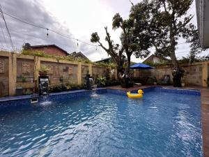 a large swimming pool with a yellow tube in it at RBD Guest House in Ungaran