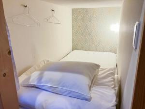 a bed with white sheets and pillows in a room at Cafe&Hostel Kimi to Ichigo in Osaka