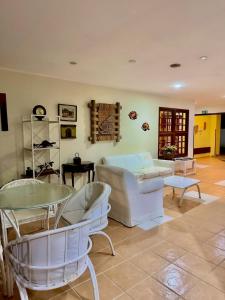 a living room with white chairs and a couch at Pauba Praia Hotel in Pauba +46 photos