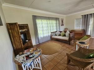 a living room with a couch and a table at Schuilhoek Farm House at Ngweni Private Game Farm in Hluhluwe