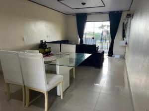a living room with a glass table and white chairs at Pousada Taylor in Foz do Iguaçu