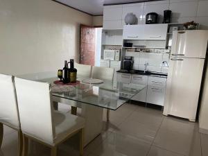 a kitchen with a glass table and white refrigerator at Pousada Taylor in Foz do Iguaçu +24 photos