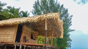 a hut with a straw roof and a tree at Villa Homestay in Mesemta