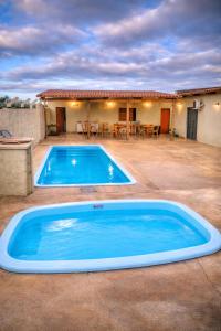 a large blue swimming pool in front of a house at Pousada Iraquara in João Pessoa