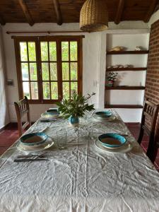 a table with plates and a plant on top of it at La Cabaña de Caro in Mar de Cobo +16 photos