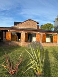 a brick house with a palm plant in front of it at La Cabaña de Caro in Mar de Cobo