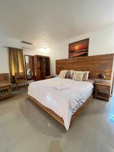 a bedroom with a large white bed in a room at Sunset Rote Bungalows in Nembrala