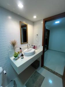 a bathroom with a sink and a mirror at Apartamento Charmoso e Tranquilo para sua Estadia in Vargem Alta +37 photos