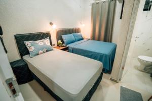 a small room with two beds and a toilet at Hotel Urban Biz in Pilar