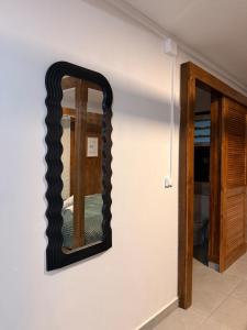 a mirror on a wall next to a door at Zabitant Lodge Éliane in Vieux-Habitants