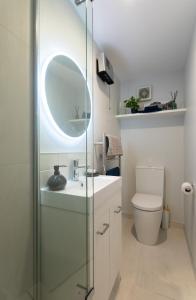 a bathroom with a sink and a mirror and a toilet at Stylish Lyttelton Studio Free Parking in  Lyttelton