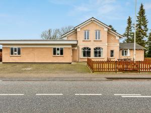 a large house with a wooden fence in front of it at Expansive Villa near Ribe in Skærbæk