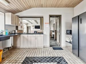 a kitchen with white cabinets and a tile floor at Expansive Villa near Ribe in Skærbæk