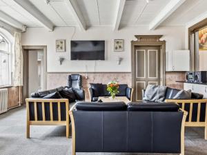 a living room with a table and chairs and a tv at Expansive Villa near Ribe in Skærbæk