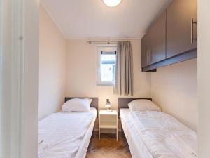 two beds in a small room with a window at Bright Beachside Base in Burgh-Haamstede in Burgh Haamstede +30 photos