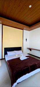 a bedroom with a large bed with a wooden ceiling at Calamianes Homestay in Coron +46 photos