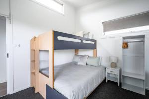 a small bedroom with a bunk bed and a small table at 550m to Beach, SPA and Large Backyard , Sleep 9 in Ocean Grove +40 photos