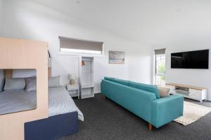 a living room with a couch and a bed at 550m to Beach, SPA and Large Backyard , Sleep 9 in Ocean Grove