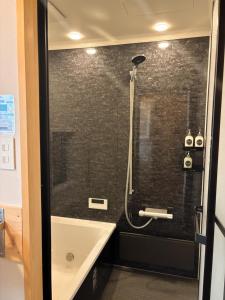 a bathroom with a shower with a black tiled wall at Tiny House - Vacation STAY 12059v in Ōtakuchi +21 photos