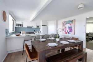 a kitchen and dining room with a wooden table and chairs at 550m to Beach, SPA and Large Backyard , Sleep 9 in Ocean Grove