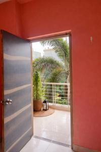 an open door leading to a balcony with palm trees at Singh ManSion in Purnea
