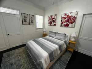 a bedroom with a bed and some pictures on the wall at Downtown Nassau Oasis Unit 2 in Nassau