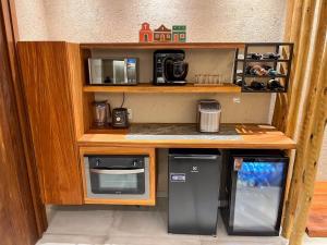a small kitchen with a stove and a microwave at Brisa e Sal in São Miguel dos Milagres +54 photos