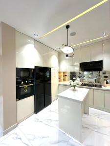 a kitchen with black appliances and white cabinets at Luxury 2 Bedroom Apartment with 2 Private Patios in Lekki Phase 1 in Lekki