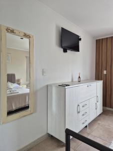 a room with a mirror and a dresser and a bed at ByF apart duplex excepcional en complejo Amaiur DPTO N5 Av Alem Norte in Federación