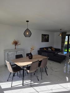 a living room with a wooden table and chairs at Villa Marie in Graignes