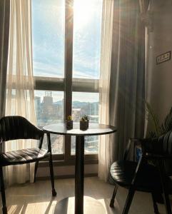 a table and chairs in a room with a window at 썸원호텔 in Yŏsu