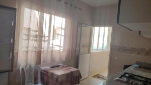a kitchen with a table and a window in a room at maison achab in Asilah
