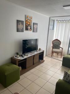 a living room with a flat screen tv and a chair at Alojamiento Parque Libertad in La Serena