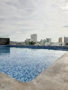 a large swimming pool with a city in the background at Comfort stay Mazatlan in Mazatlán