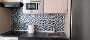 a kitchen with a sink and a microwave at Apartamento en Avilés Céntrico & Parking in Avilés