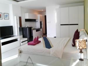 a bedroom with a bed with pink shoes on it at Grand Residence Jomtien in Jomtien Beach
