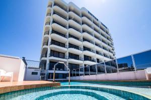 ein Hotel mit einem Schwimmbad vor einem Gebäude in der Unterkunft Bayview Tower in Yeppoon