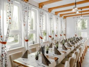 a row of tables and chairs in a room with windows at Kaiserhof Feldberg- Standard Double Room in Feldberg