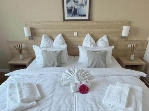 a white bed with white pillows and a box on it at Kaiserhof Feldberg- Standard Double Room in Feldberg +28 photos