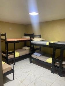 a room with three bunk beds and a table at Portal do Sol in Canoa Quebrada