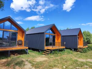 two cottages on the grass with a sky background at Noygut in Dzhetyoguz +6 photos