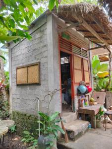 a small brick house with a table and a door at Nostalgia Camping Home 1 in Selemadeg