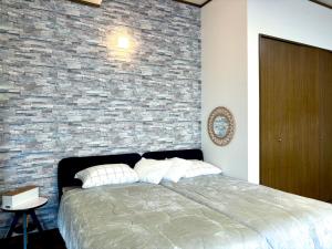a bedroom with a brick wall and a bed at mahoratto inn in Aomori +18 photos