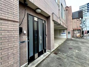 a door to a building with a parking lot at mahoratto inn in Aomori