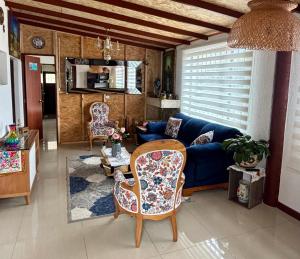 a living room with a blue couch and chairs at Casa campestre Hotel Cerro Fuerte in Sopo