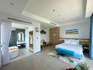 a bedroom with a bed and a bathtub and a bath tub at Odin Hotel Quy Nhon in Quy Nhon